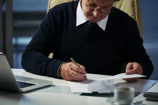 Homme d'affaires vérifiant le document financier sur sa table